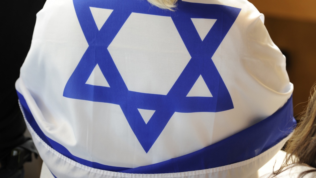 Eine Frau hat sich eine israelische Fahne umgehängt. 